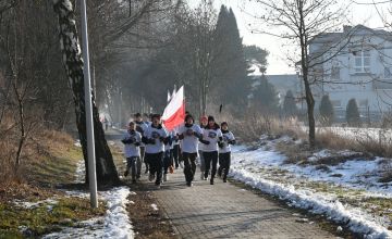 Młodzież biegnąca z flagą